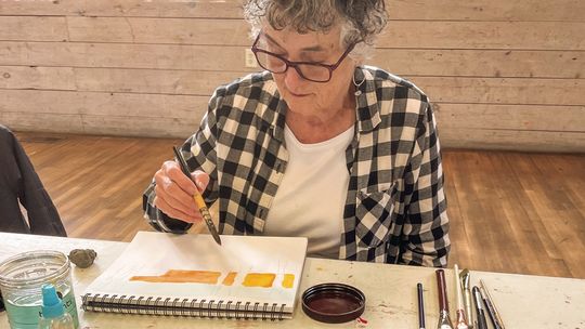 Carol Geiger takes her time painting her families annual Christmas Card Tuesday during a drop-in artist session at the Old Art Building in Leland. Enterprise photo by Brian Freiberger