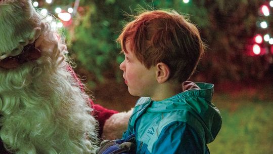 Magnus Goodell, son of Matt and Nora Goodell of Lake Leelanau, was in awe of Santa Claus at the Light Up Leland celebration in 2023 that kicked off the holiday season. Courtesy photo