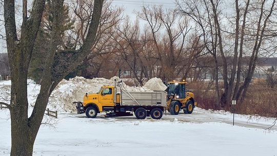 Department of Public Works crews from the Village of Suttons Bay deposit snow removed from the streets at the village marina