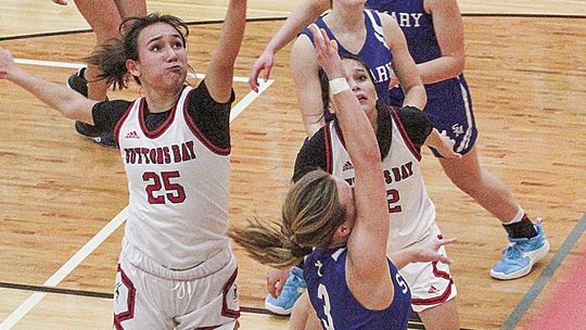 Suttons Bay senior Keeley TwoCrow blocks St. Mary’s Cathryn Mikowski as she drives to the basket.