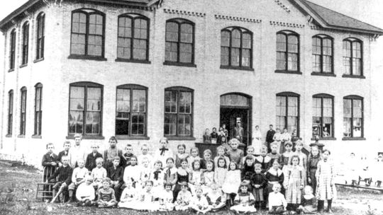 Early S-B students taught in a log cabin