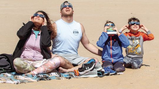 The McGeathe family enjoy the solar eclipse from the Dune Climb within the Sleeping Bear Dunes National Lakeshore on Monday, April 8. The eclipse occasion brought hundreds of people to the Dune Climb to enjoy the once-in-a-lifetime event. From left to right: Tracy, Dave, Lance, Hunter. Ent...