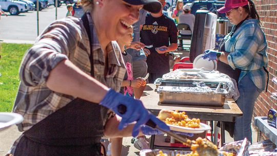 Volunteers Heidi Lindeman (foreground) and Liz Tondreau (background) served food at the pig roast.