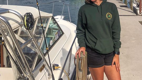 Brianna Abercrombie, who gathers information about salmon and lake trout catches off the shoreline of Leelanau County, must be in the right occupation. She enjoys fishing so much that she goes out after work despite having examined dead fish all day. Enterprise photo by Alan Campbell