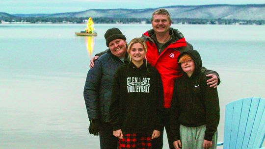 The Siepker family poses for a photo at their Glen Lake home where they bring holiday cheer to the area by setting up a christmas tree on a small rowboat that lights up the Leelanau sky. From left to right: Traci, Ashley, Frank Jr., and Frank III. Enterprise photo by Brian Freiberger