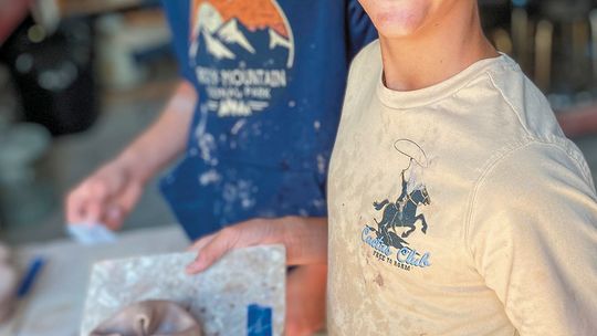 Glen Lake Middle School student Samuel Feeney is pictured with Connor McCaw in the background during a recent Glen Arbor Art Center (GAAC) monthly class. The new partnership between LIFT and GAAC gives students at Glen Lake Middle School the chance to take various art classes. Courtesy pho...