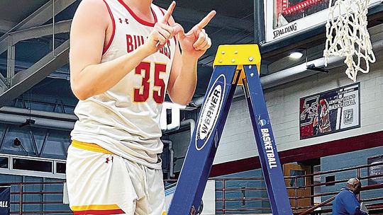 Ferris State redshirt junior Reece Hazelton cuts down the net after winning a regional championship in the NCAA DII men’s basketball championships. Courtesy photo