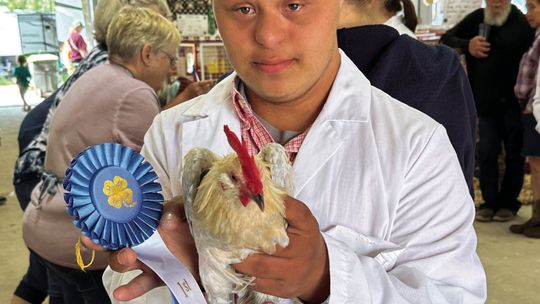 J.C. Oosse, a Lake Leelanau youth in the Michigan State University Leelanau County Extension’s 4-H Program, poses with one of his two animal projects, a bantam cock that placed first in its class at the Northwestern Michigan Fair Monday. Courtesy photo by Linda Oosse