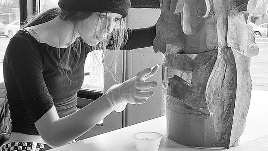 Northport Public School sophomore Valerie Glidden is pictured working on her sculpture at school which will be featured in the “J is for the Juxtaposition” student art exhibition on display next Thursday. Photo courtesy of Jenny Evans