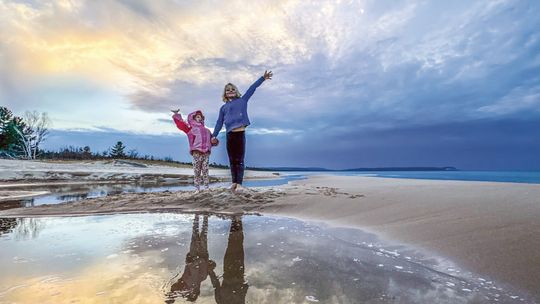 Juniper and Zinnia Schaberg, ages 8 and 3 respectively, greeted an early spring with bare feet last week at the mouth of the stream that feeds Good Harbor. Photo courtesy of James Schaberg