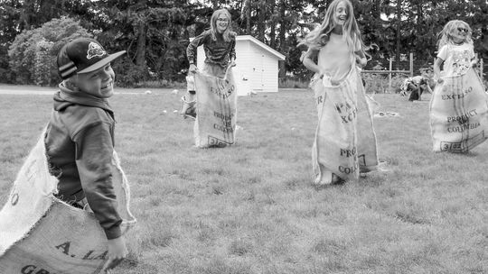 Kids enjoy a “good old fashioned” burlap sack race at the Olsen farm. Family games are just one of the many interactive and hands-on activities at the Port Oneida Fair, Aug. 10 and 11. Photo courtesy of the National Park Service.