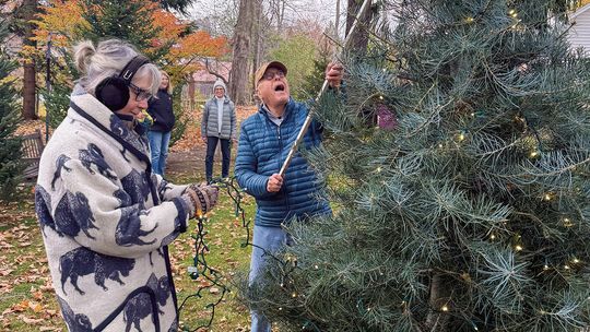 Kim McManama and Mike Mott place lights on trees