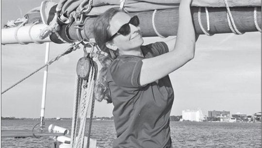 Juliana Lisuk, associate director of Inland Seas Education Association, stands aboard the schooler Alliance on the waters of Grand Traverse Bay. Courtesy photo