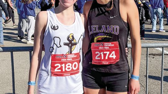 Glen Lake freshman Carmella Julian (left) and Leland senior Ella Knudsen share a moment after the state championship race at Michigan International Speedway Saturday. Courtesy photo