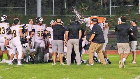 Glen Lake coach Jesse Smith received a cold shower after watching his Lakers win a close and crucial Northwest Conference football game 7-6 Friday. Photo Courtesy of Michele Aucello