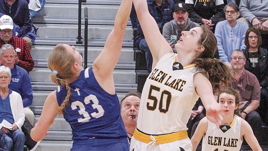 Lake Leelanau St. Mary senior Leah Fleis (left) and Glen Lake senior Eleanor Valkner jump for ball at the beginning of a division 4 basketball game.