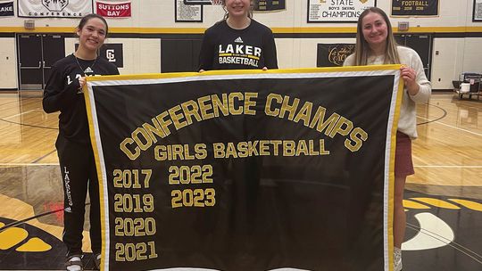 Glen Lake girls basketball celebrated its senior night Tuesday as Ava Raymond (left), Eleanor Valkner, and Paige Steffke hold the Laker banner with the team's accomplishments over the past several years. Courtesy photo