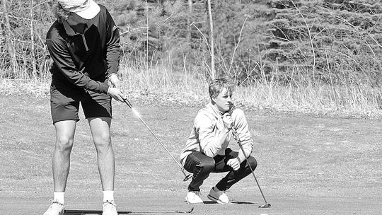 Glen Lake senior Jacob Switzer (left) putts while junior Michael Houtteman (right) prepares for his shot during practice at the Dunes Golf Club earlier this week. Enterprise photo by Brian Freiberger