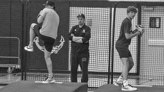 Glen Lake pitchers Keaton Lacross (left) and Justin Halvka (right) warm up during practice indoors on Tuesday. Enterprise photo by Brian Freiberger