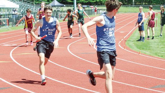Lake Leelanau St. Mary runners Derek Graham hands off to Garrick Collins during a MHSAA Div. 4 regional on Saturday. The 4x800-relay team of Oliver Mitchell, Garret Grant, Graham, and Collins qualified for the state track meet for the first time in school history. Enterprise photos by Bria...