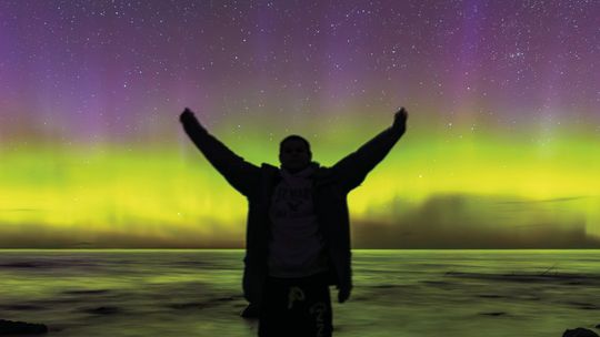 Leelanau night photographer Ethan Hohnke takes a self portrait under a strong aurora on the shores of Lake Michigan. Courtesy photo