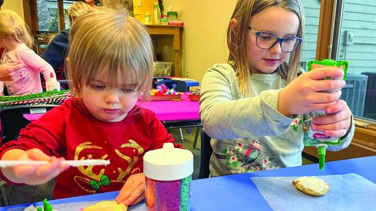 Madison and Savannah Potes, from left, are shown decorating cookies at a recent Parenting Communities event. The girls are from Northport. Photo courtesy of Courtney Yaple
