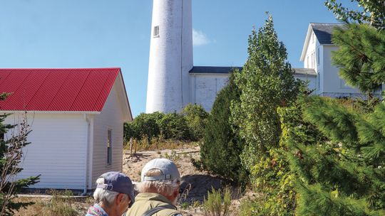 Mainland visitors took in the beauty of the South Manitou Lighthouse during a day trip hosted by the Leelanau Historical Society Monday. Enterprise photo by Brian Freiberger