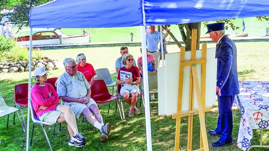 A group gathered under a tent at the Maritime Festival and Wooden Boats on the Wall celebration Saturday in Leland. Enterprise photo by Zachary Marano