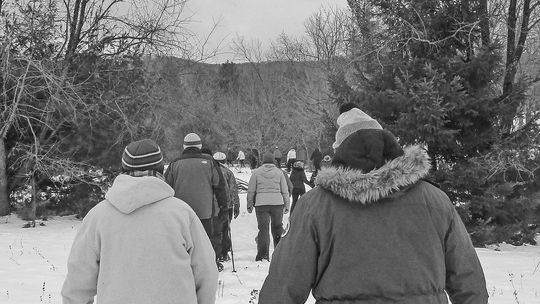 A group of visitors hiking through the snow with a park ranger at Sleeping Bear Dunes National Lakeshore. Photo courtesy of the National Park Service.