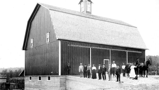 A photograph of the Poor Farm Barn in 1911 shows the original cupola atop the barn’s roof. The builder of the barn, John Schettek, is within the foreground. Photo courtesy of Leelanau County Historic Preservation Society
