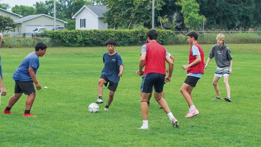 Suttons Bay sophomore Julian Garcia dribbles between teammates during a drill at practice last week. Enterprise photo by Brian Freiberger
