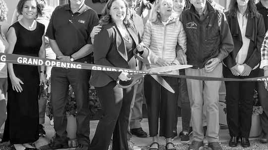 Dr. Carrie Sands of Leland (middle) cut the ribbon to her new sports chiropractic office in Leland in May. Courtesy photo