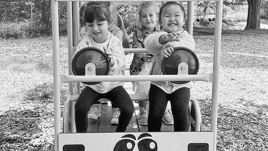 St. Mary preschoolers Madelyn Loomis, Olivia Hebert and Valentine Moua enjoy driving the new St. Mary School playground bus generously funded by the Oleson Foundation. Courtesy photo
