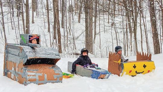 The annual Pack 131 Cub Scouts cardboard sled race at Bahle Hill in Suttons Bay on Saturday. Seth Courtade in the tank (left), Declan Draper in the Bismarck (middle), and Zac Richter in the Pokeman Cruiser (right). Photo courtesy of Lynn Bakker