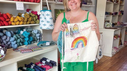 Liz Neddo of Wool and honey of Cedar holds an art piece that her daughter Cecily made. Enterprise photo by Brian Freiberger