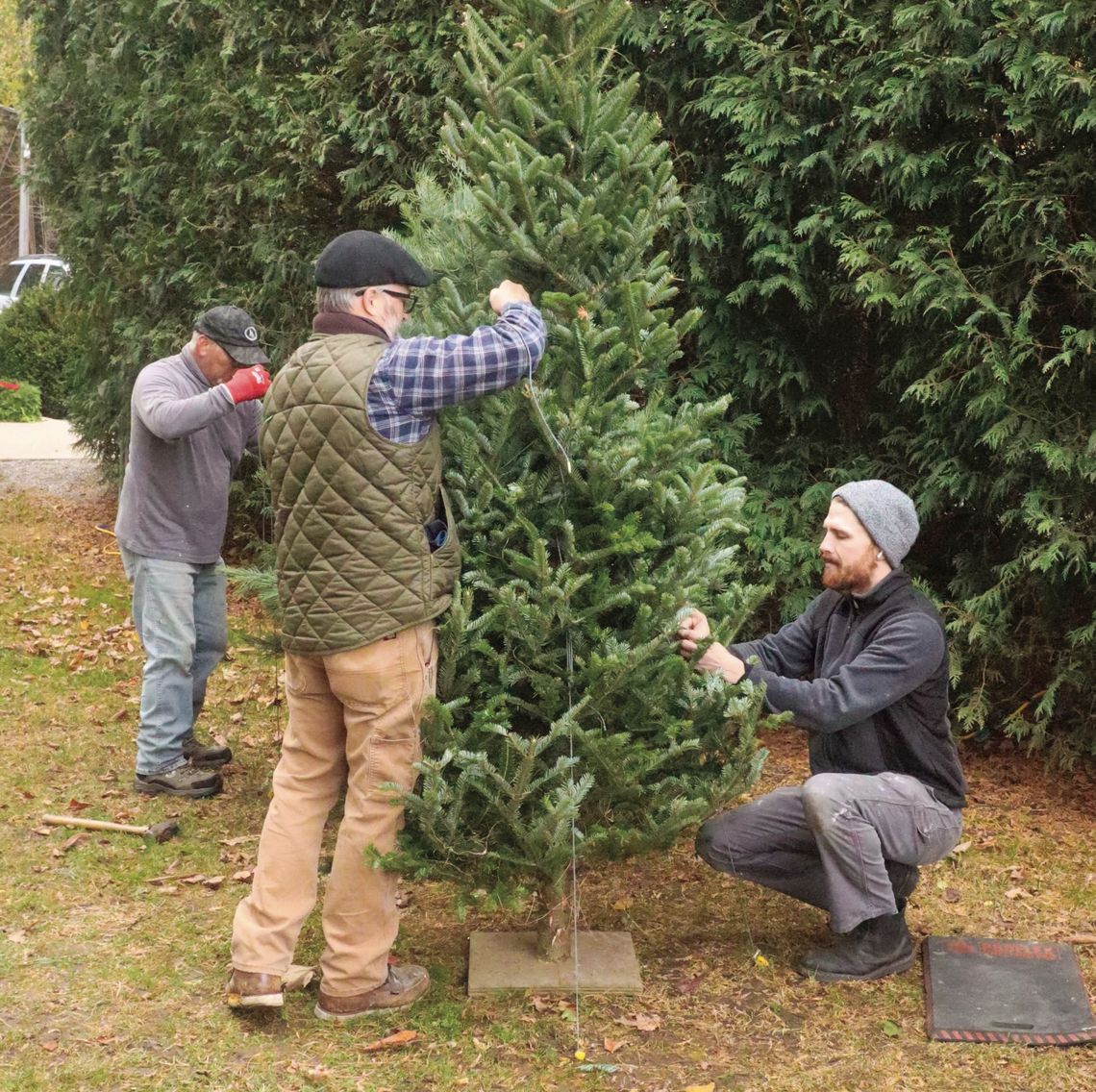 Locals Robert Ruiz (left), Scott Cain (middle), and Luke Lambdin of Cain Design &amp; Construction string up holiday lights at the Old Art building in Leland yesterday. They also put lights on various community tree including Northport, Leland and Glen Arbor. Enterprise photo by Brian Frei...