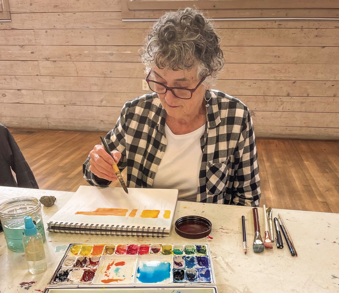 Carol Geiger takes her time painting her families annual Christmas Card Tuesday during a drop-in artist session at the Old Art Building in Leland. Enterprise photo by Brian Freiberger