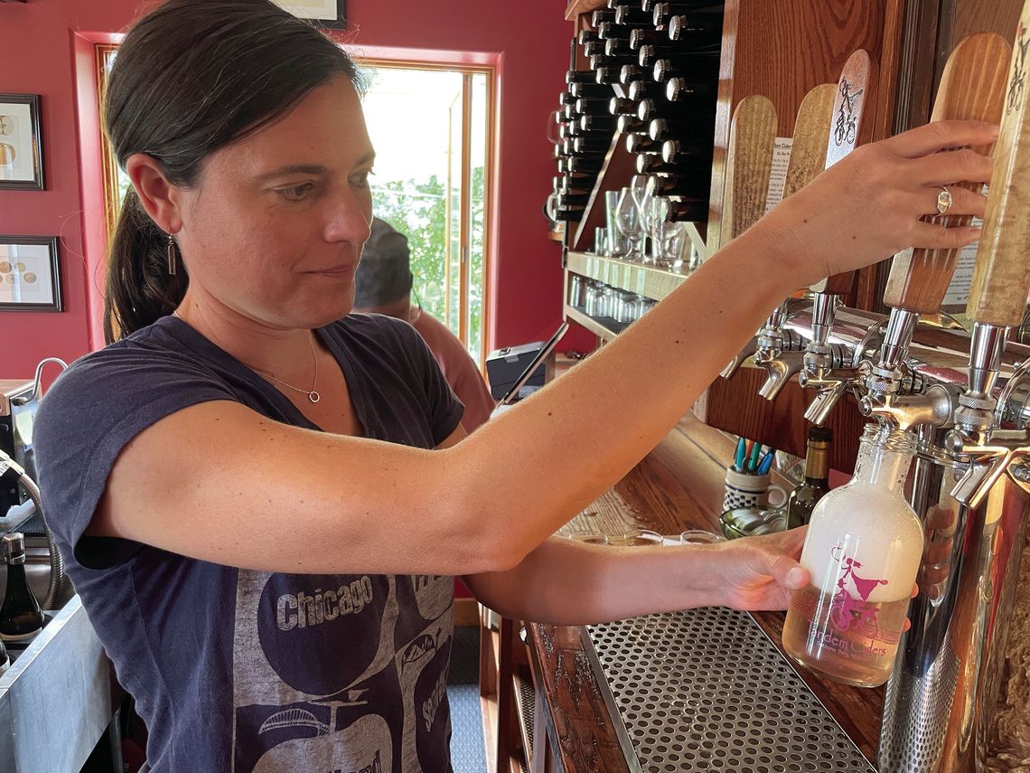 Sarah Hoskins of Tandem Ciders pours a growler full of “Sweet William” pear cider at its Suttons Bay tasting room. Enterprise photo by Brian Freiberger