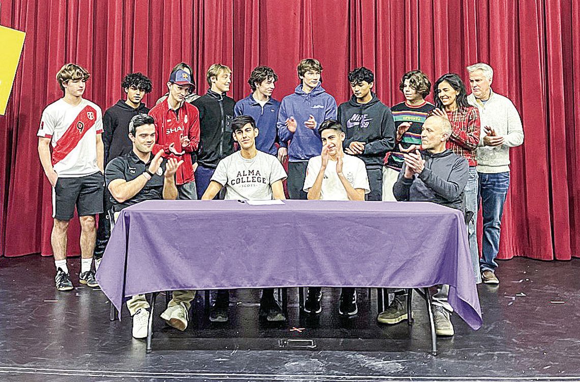 _ Leland senior Agustin Creamer (middle-left) receives a round of applause for his commitment to Alma College last week. Courtesy photo