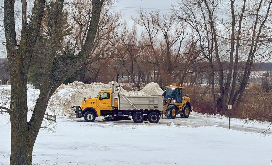 Department of Public Works crews from the Village of Suttons Bay deposit snow removed from the streets at the village marina