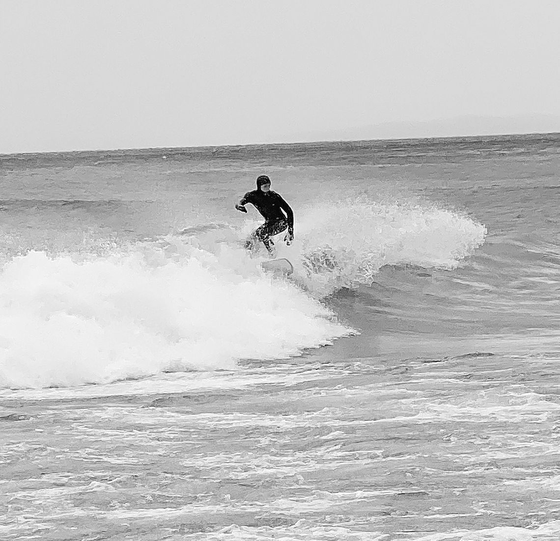 A surfer ascended to Northport to catch some waves last week during high winds as local residence enjoy the show. Courtesy photo by Ruth Barry