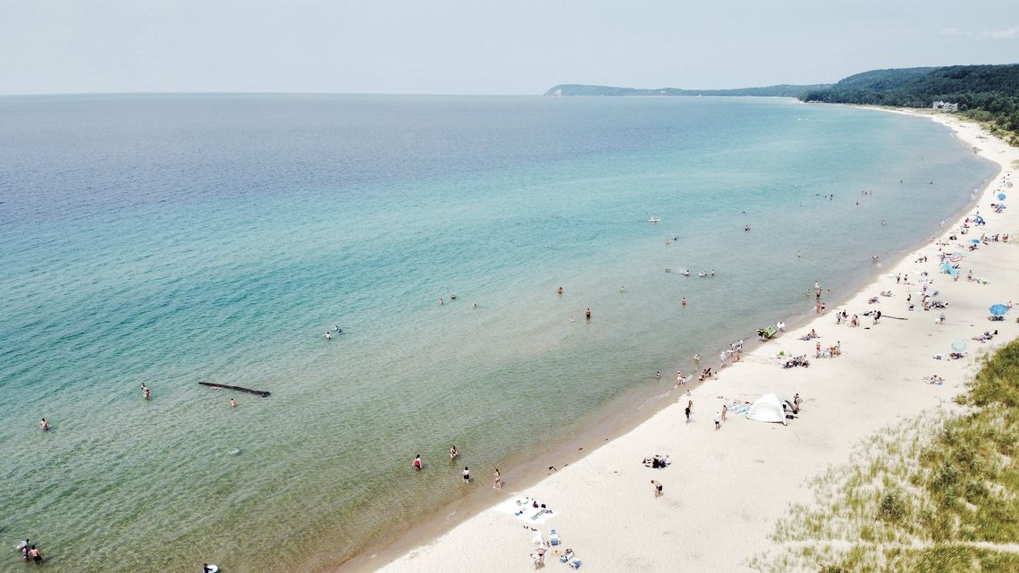 Fun in the sun Fun in the sun. Beach-goers take in the summertime weather at Good Harbor Beach in the Sleeping Bear Dunes National Lakeshore. Kids are spotted playing on a floating tree that washed up near shore while other catch some rays and look for treasures along the shore of the beach. Enterprise p...
