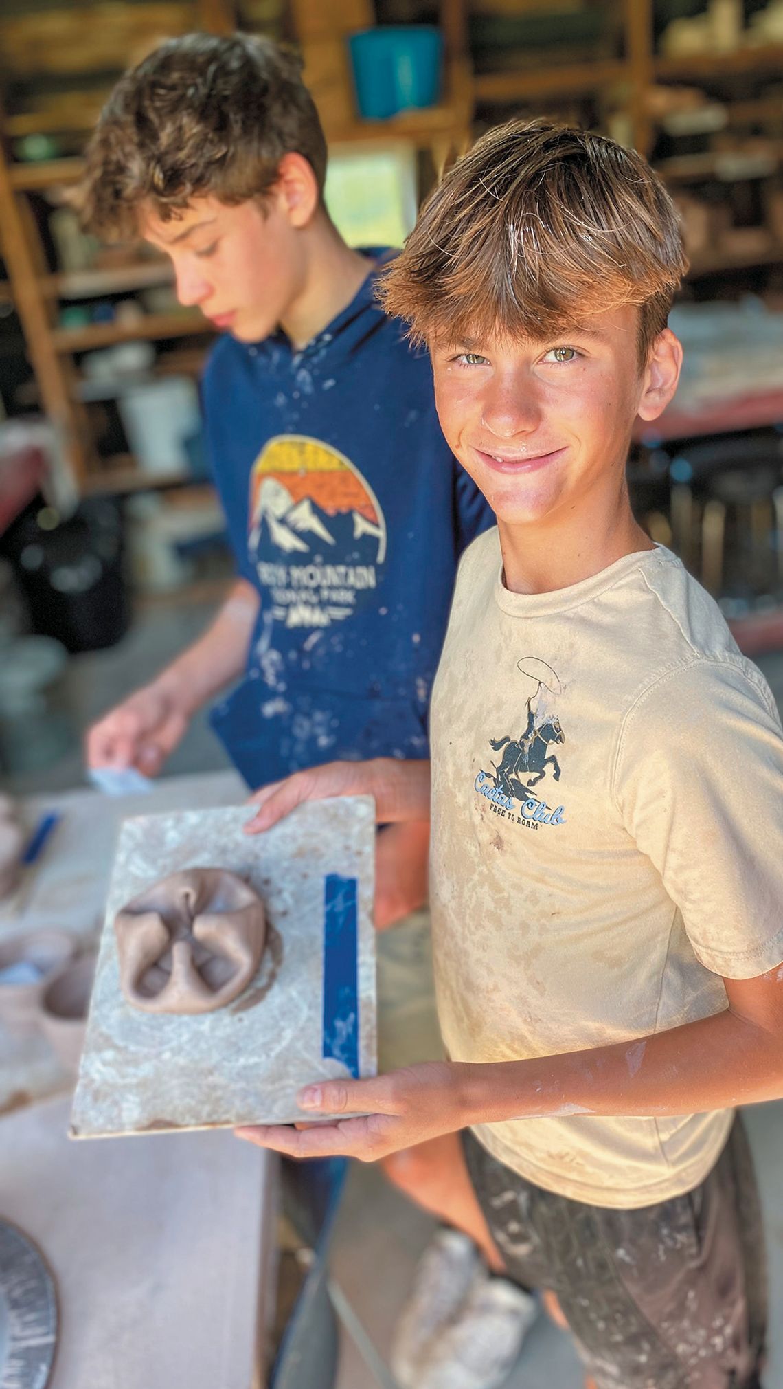 Glen Lake Middle School student Samuel Feeney is pictured with Connor McCaw in the background during a recent Glen Arbor Art Center (GAAC) monthly class. The new partnership between LIFT and GAAC gives students at Glen Lake Middle School the chance to take various art classes. Courtesy pho...