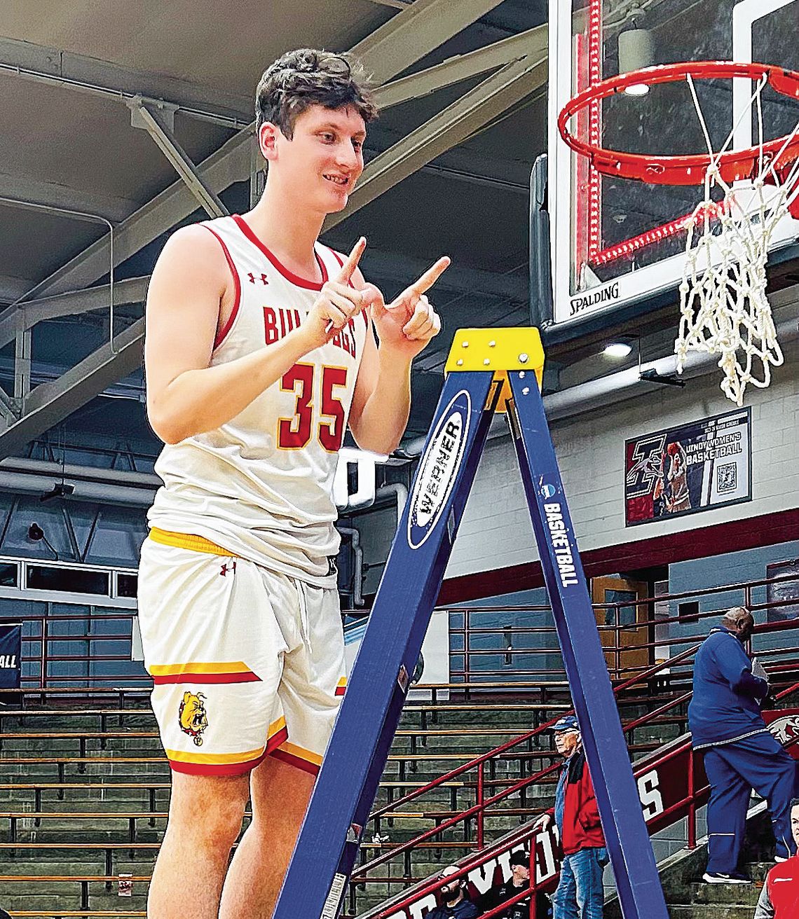 Ferris State redshirt junior Reece Hazelton cuts down the net after winning a regional championship in the NCAA DII men’s basketball championships. Courtesy photo