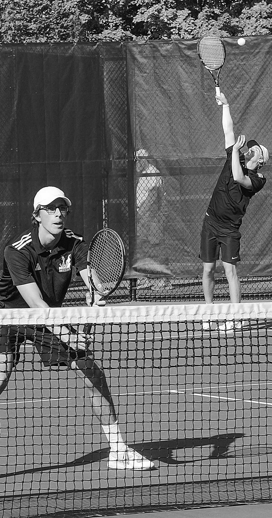 Glen Lake senior Ben Selby serves while Lake Leelanau St. Mary junior Oliver Mitchell prepares for a return against TC St. Francis Wednesday. Enterprise photos by Brian Freiberger