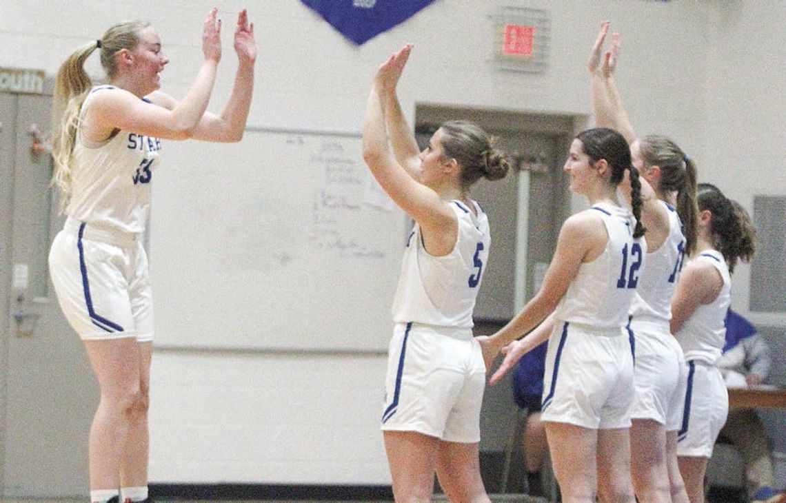 Lake Leelanau St. Mary senior Leah Fleis jumps to give her teammates high-five’s before beating Kalkaska on Friday night. Enterprise photo by Brian Freiberger