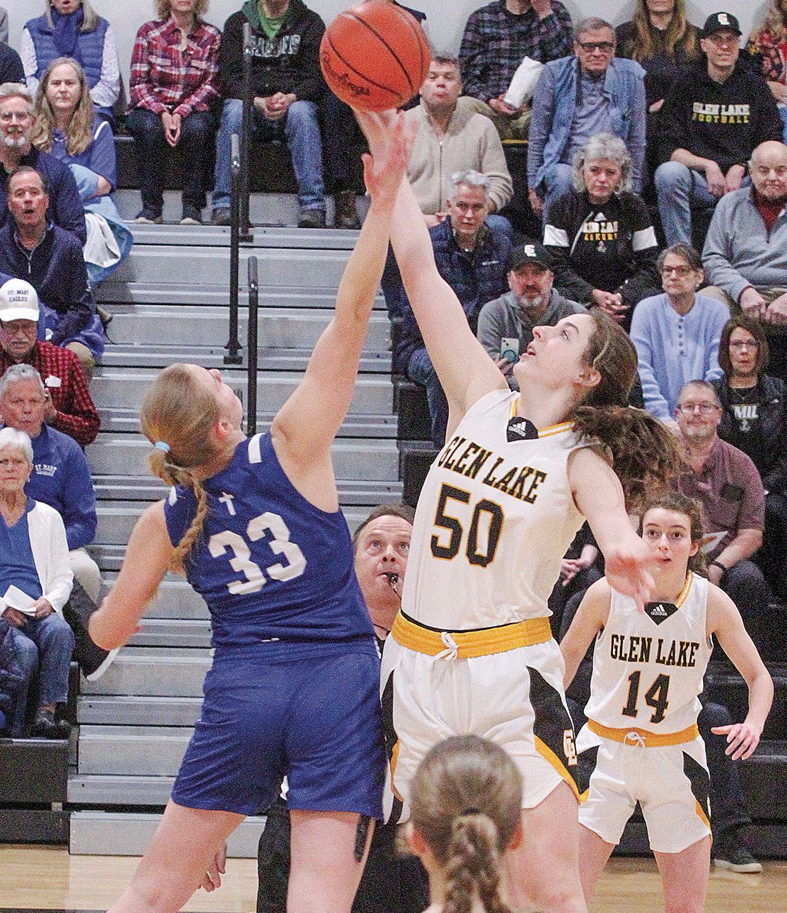 Lake Leelanau St. Mary senior Leah Fleis (left) and Glen Lake senior Eleanor Valkner jump for ball at the beginning of a division 4 basketball game.