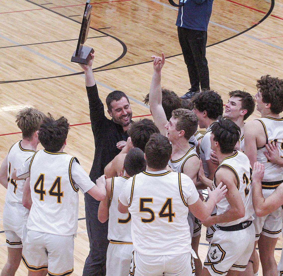 The Glen Lake boys basketball team celebrates after capturing its first regional championship since 2018. Enterprise photos by Brian Freiberger