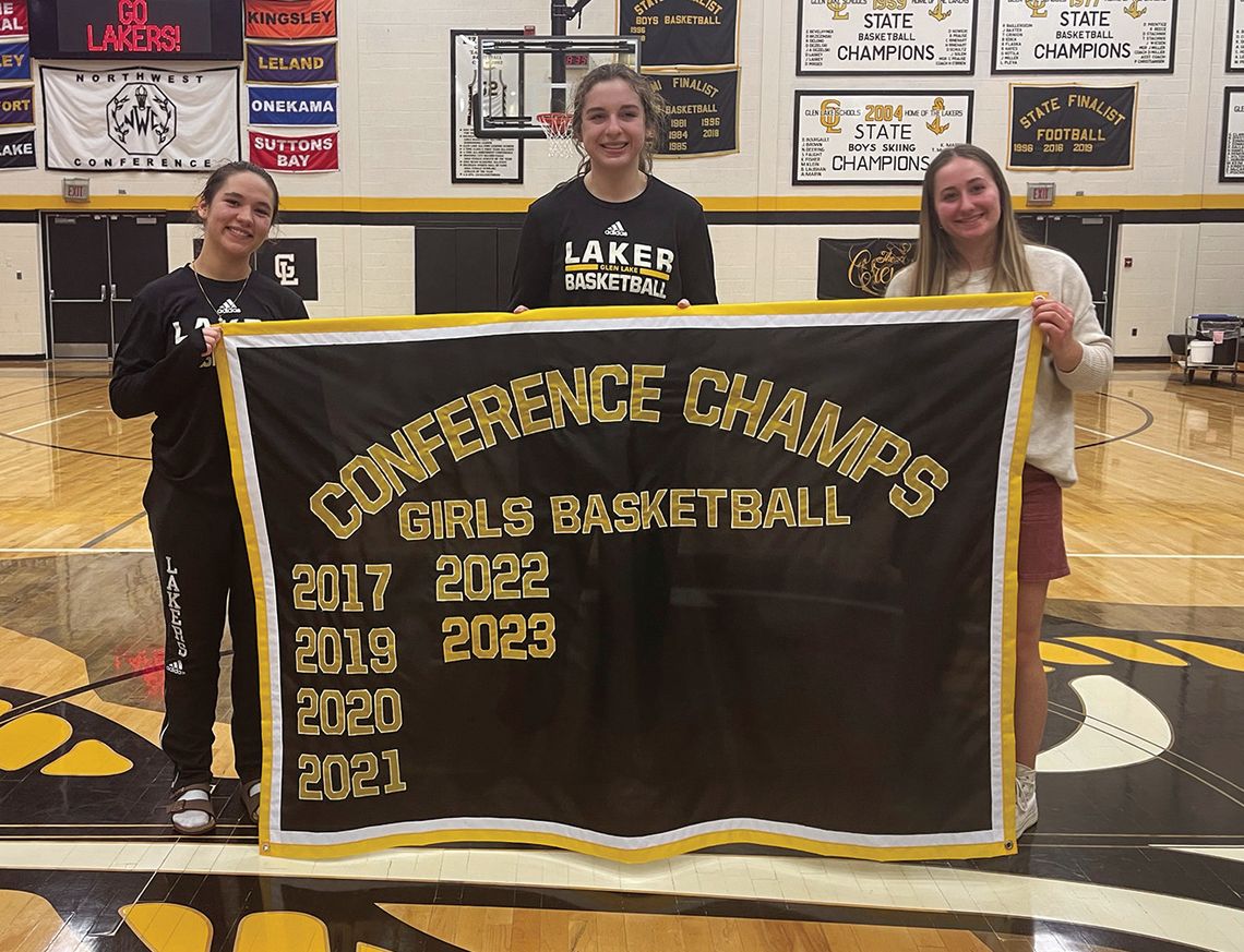 Glen Lake girls basketball celebrated its senior night Tuesday as Ava Raymond (left), Eleanor Valkner, and Paige Steffke hold the Laker banner with the team's accomplishments over the past several years. Courtesy photo