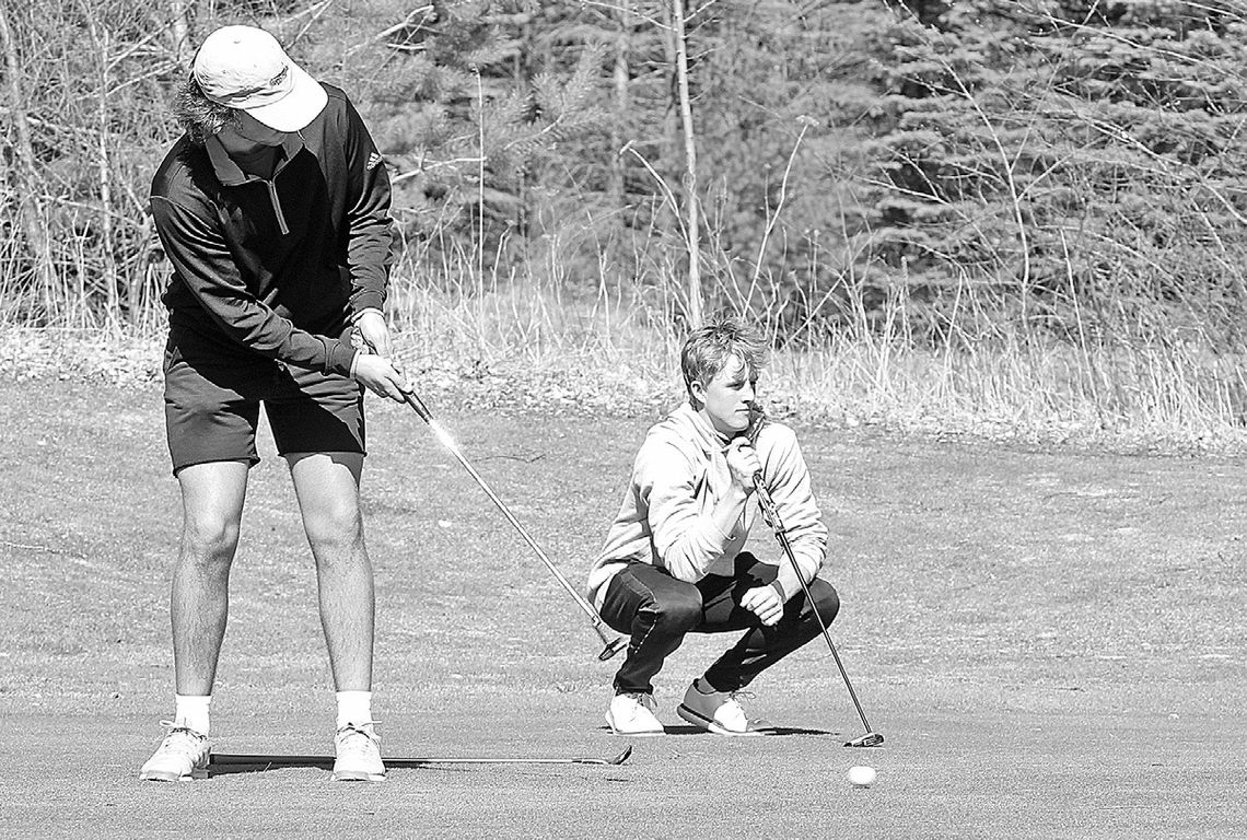 Glen Lake senior Jacob Switzer (left) putts while junior Michael Houtteman (right) prepares for his shot during practice at the Dunes Golf Club earlier this week. Enterprise photo by Brian Freiberger